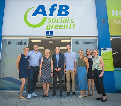 AfB & refurbed Team gemeinsam mit BM Leonore Gewessler vor dem AfB-Shop © BMK/Cajetan Perwein